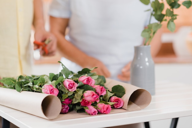 El par mayor asiático que hace el ramo florece en una tabla de madera en cocina en casa.