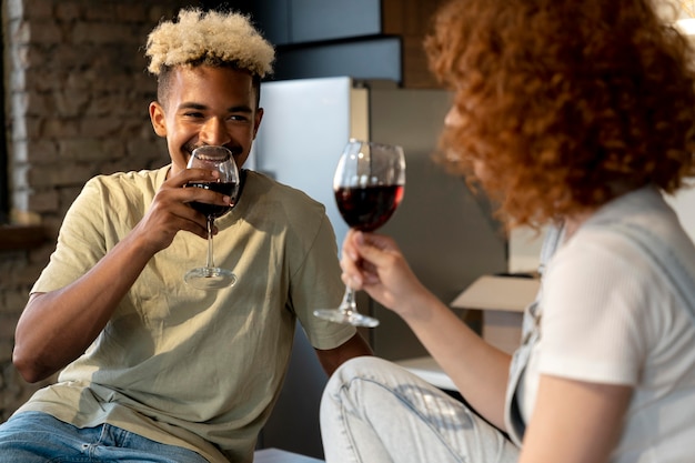 Foto gratuita par tomar vino juntos en la cocina de su nuevo hogar