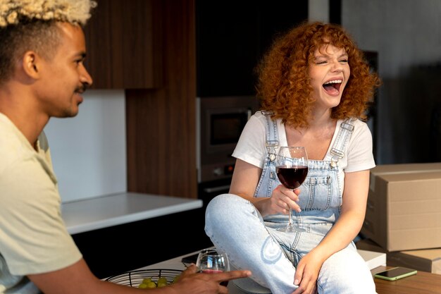 Par tomar vino juntos en la cocina de su nuevo hogar