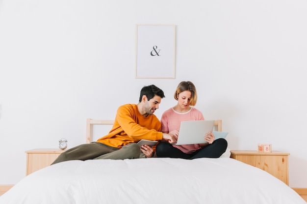 Par usando la computadora portátil en la cama