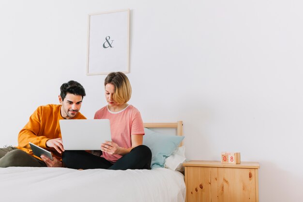 Par usando la computadora portátil en el dormitorio