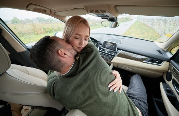 Par de viajeros chico y chica abrazándose en el auto