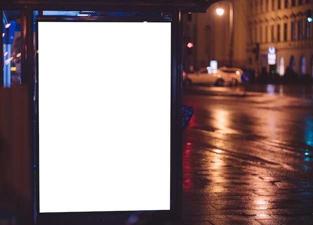 Parada de autobús durante la noche con espacio publicitario