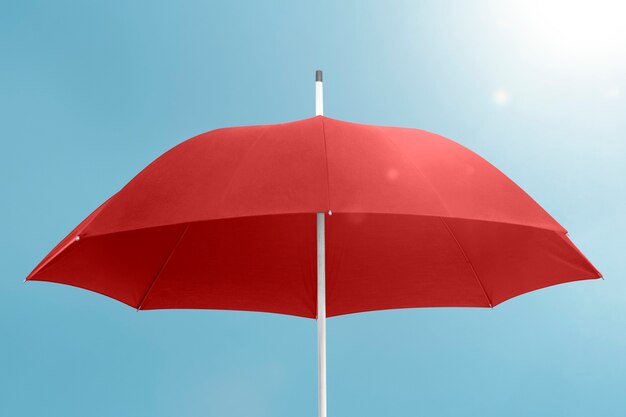 Paraguas rojo con espacio de copia en el cielo azul