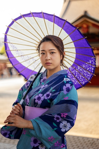 Foto gratuita paraguas wagasa japonés ayudado por mujer joven