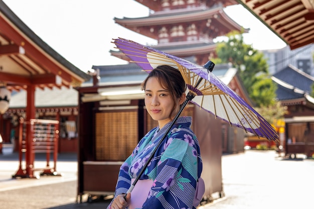 Paraguas wagasa japonés ayudado por mujer joven