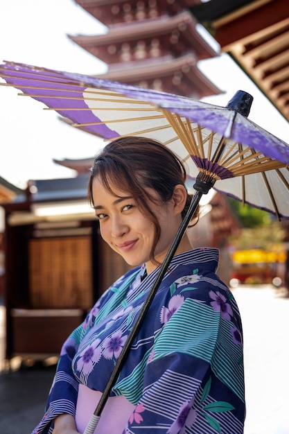 Foto gratuita paraguas wagasa japonés ayudado por mujer joven