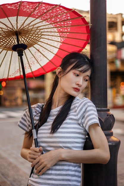 Foto gratuita paraguas wagasa japonés ayudado por mujer joven