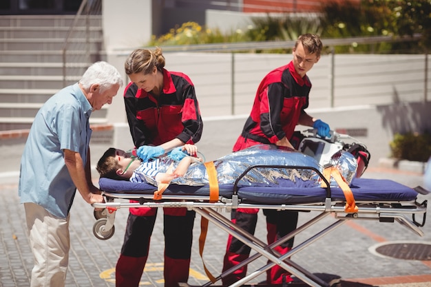 Paramédicos examinando niño herido