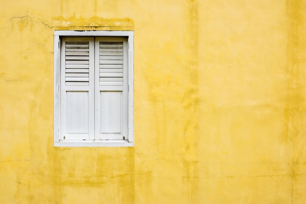 Pared amarilla y una ventana blanca