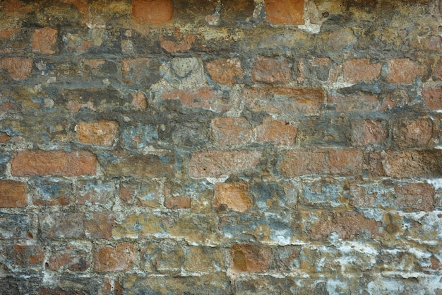 Pared antigua desconchada de ladrillos