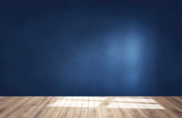 Pared azul oscuro en una habitación vacía con piso de madera