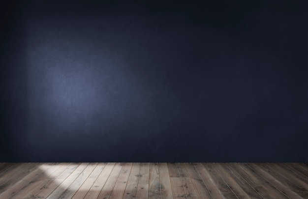 Pared azul oscuro en una habitación vacía con piso de madera