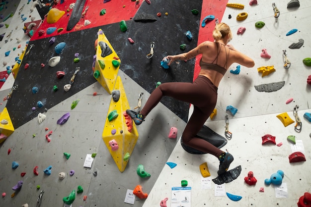 Pared de escalada de mujer de tiro completo