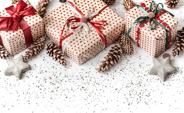 Pared festiva de año nuevo blanco con regalo atado con cinta roja.