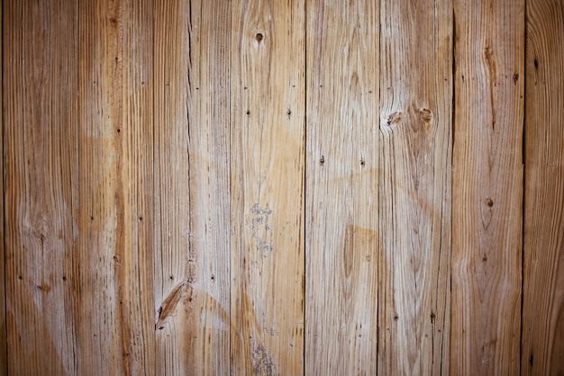 Pared hecha de tablones verticales de madera marrón.