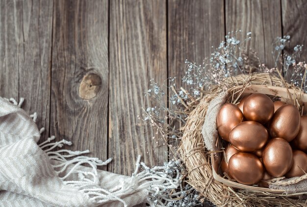 pared con huevos de Pascua dorados en la pared de madera.