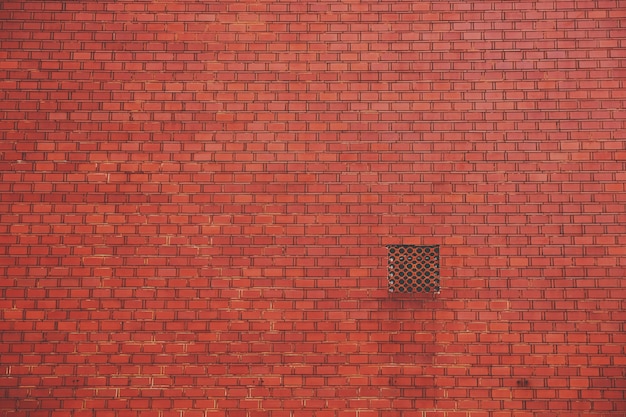 Pared de ladrillo rojo con ventilación cuadrada