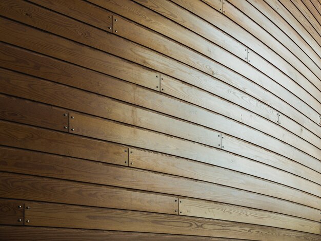 Pared de madera con clavos bajo la luz solar.