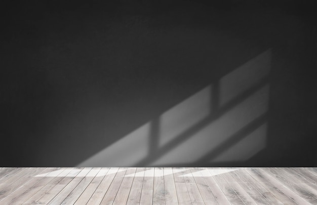 Pared negra en una habitación vacía con piso de madera.