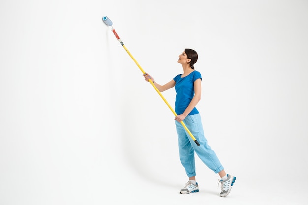 Pared de pintura de mujer joven, hacer trabajos de reparación