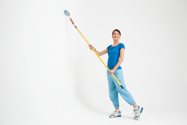 Pared de pintura de mujer joven, hacer trabajos de reparación