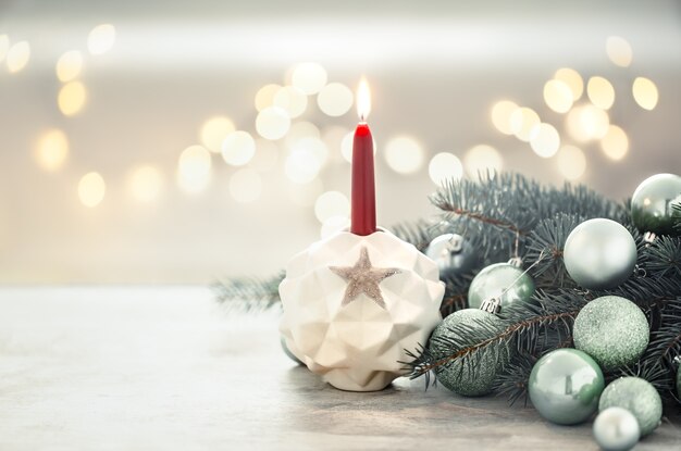 Pared de vacaciones de Navidad con una vela en un candelero.