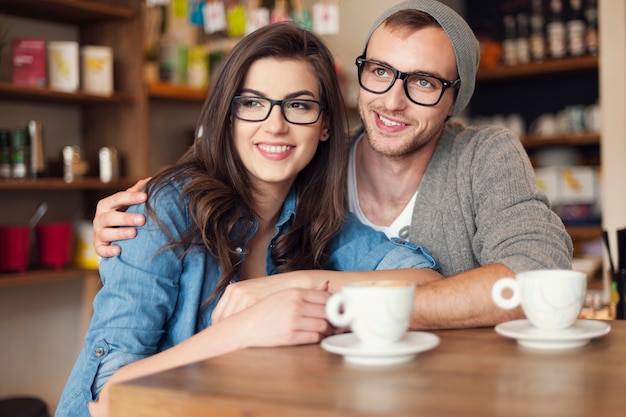 Pareja abrazada gastando juntos en el café