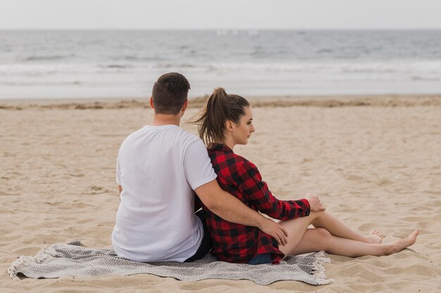 Pareja abrazada posando en la playa