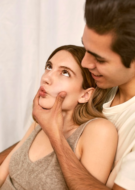 Pareja abrazada sonriente haciendo muecas