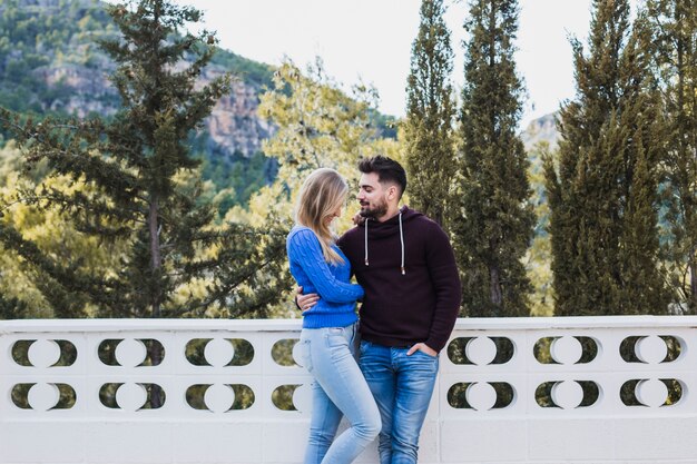 Pareja abrazados en la terraza cerca del bosque