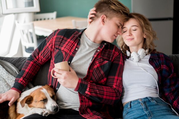 Pareja abrazándose al lado del perro