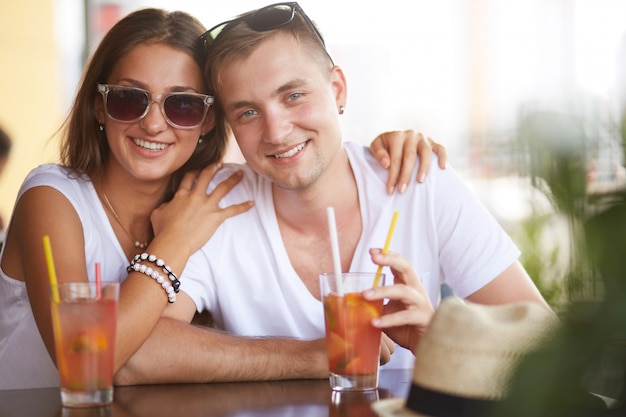 Pareja abrazándose y bebiendo un refresco