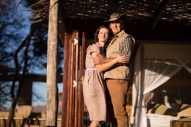 Pareja abrazándose en cabaña durante vacaciones de safari