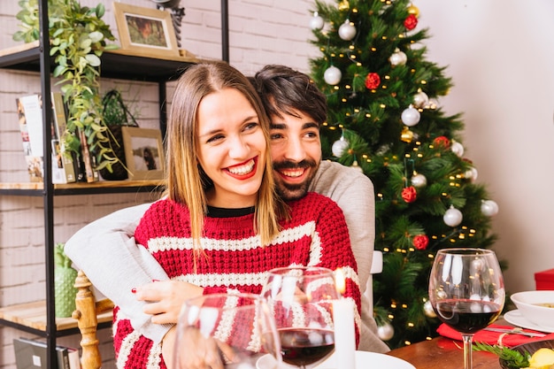 Pareja abrazándose en cena de navidad