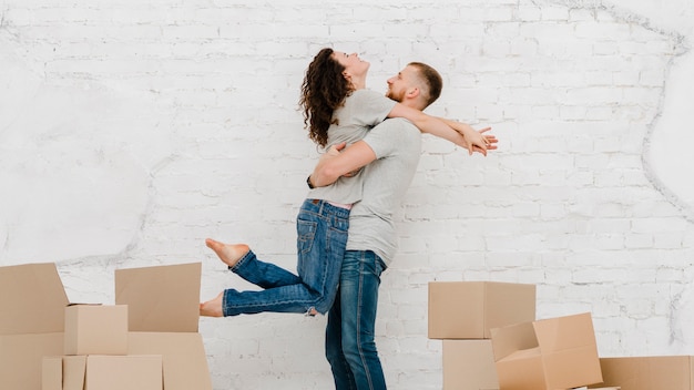 Pareja abrazándose cerca de cajas