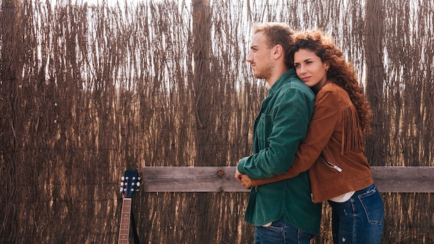 Foto gratuita pareja abrazándose lateralmente con copia espacio