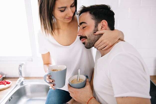 Pareja abrazándose mientras bebe café