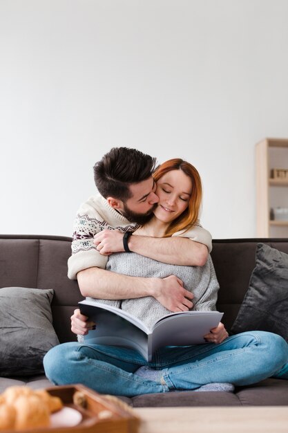 Pareja abrazándose mirando un libro