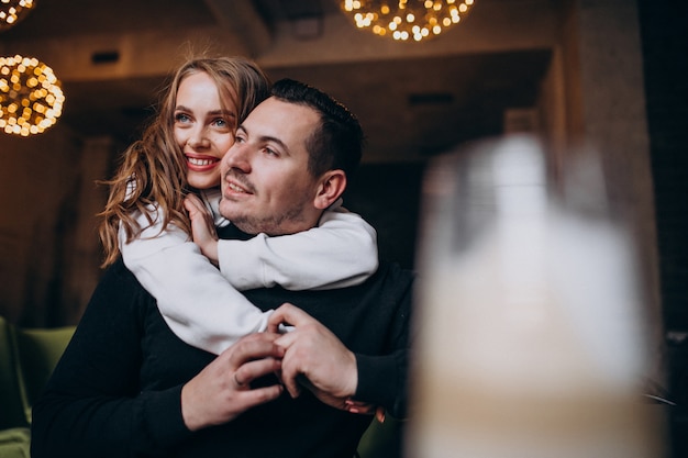 Pareja abrazándose y sentados juntos dentro de un café