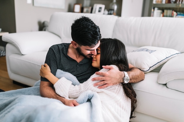 Pareja abrazándose sentados en una manta