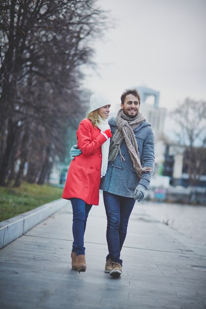 Pareja con abrigos de invierno paseando