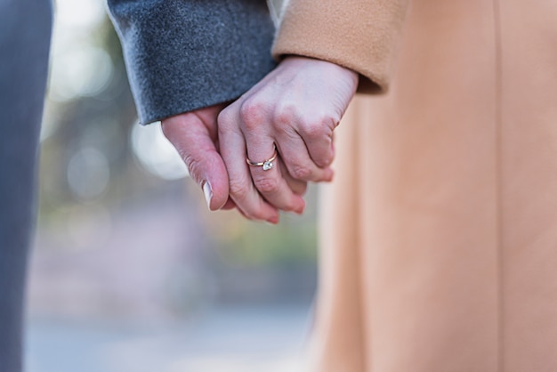 Pareja en abrigos tomados de la mano