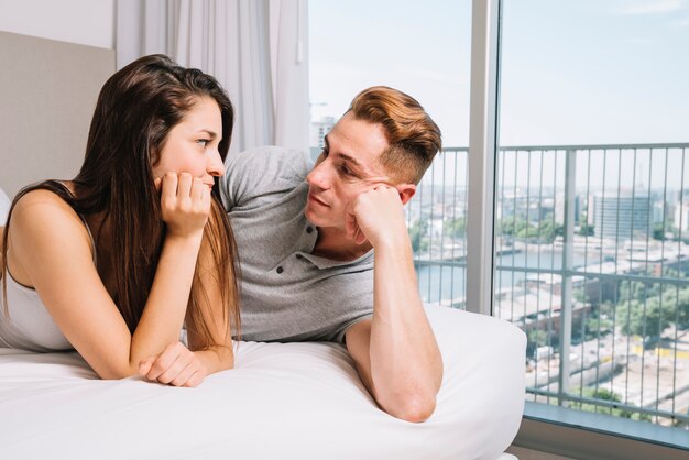 Pareja acostada y mirando el uno al otro