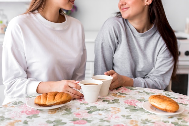 Pareja adolescente tomando café en la mesa