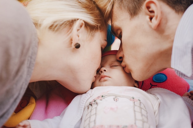 Pareja adorable besando a su hija