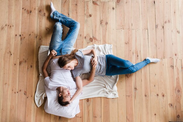 Pareja adulta abrazando en hoja en piso