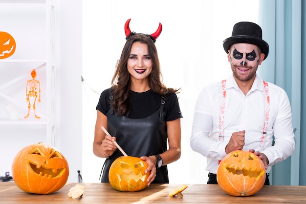 Pareja adulta con calabazas para halloween