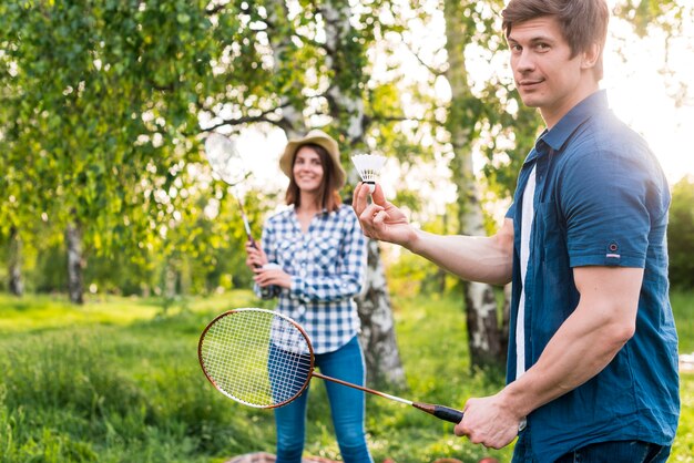 Pareja adulta jugando bádminton en el parque