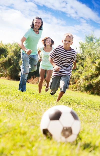 Foto gratuita pareja de adultos y adolescente jugando con balón de fútbol